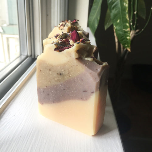 Natural, golden, and purple soap with dried botanicals on top