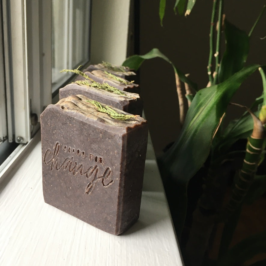 Deep purple soap topped with evergreen branches stamped with 